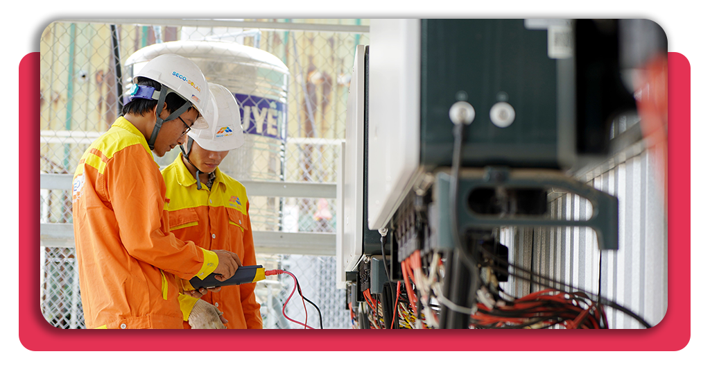 Dos hombres jóvenes trabajando en el área tecnológica de una empresa. Cada uno cuenta con casos protectores y uniformes adecuados para el trabajo