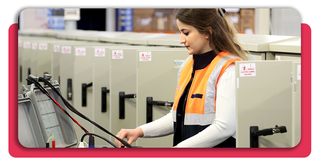 Mujer joven trabajando activamente en el área de automatización industrial de una empresa. No lleva casco ni guantes protectores.