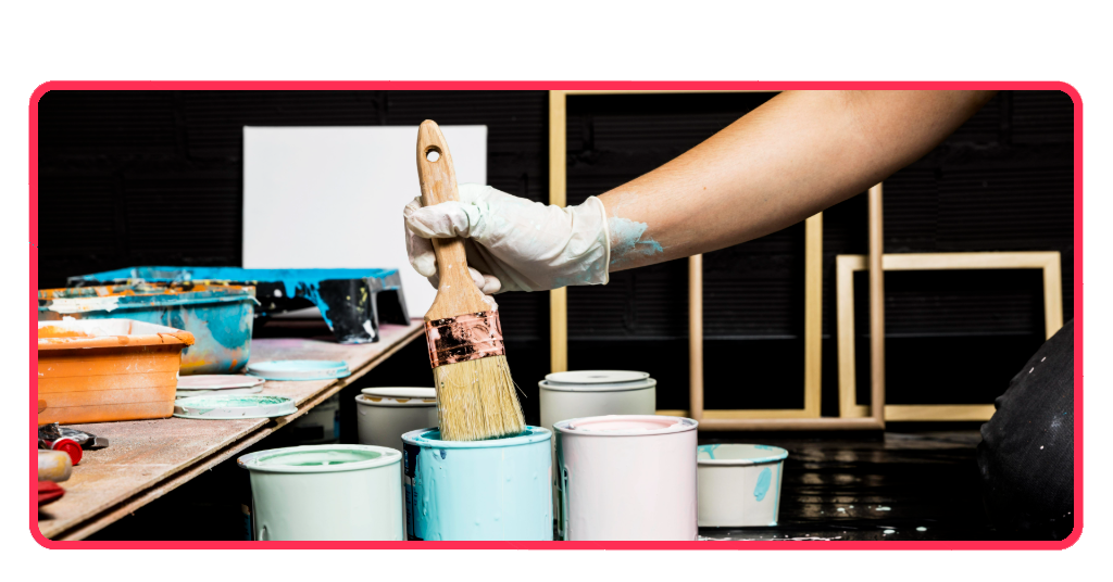 Pintores profesionales utilizando brochas y botes de pintura de diferentes colores para renovar y decorar las superficies de una vivienda en España