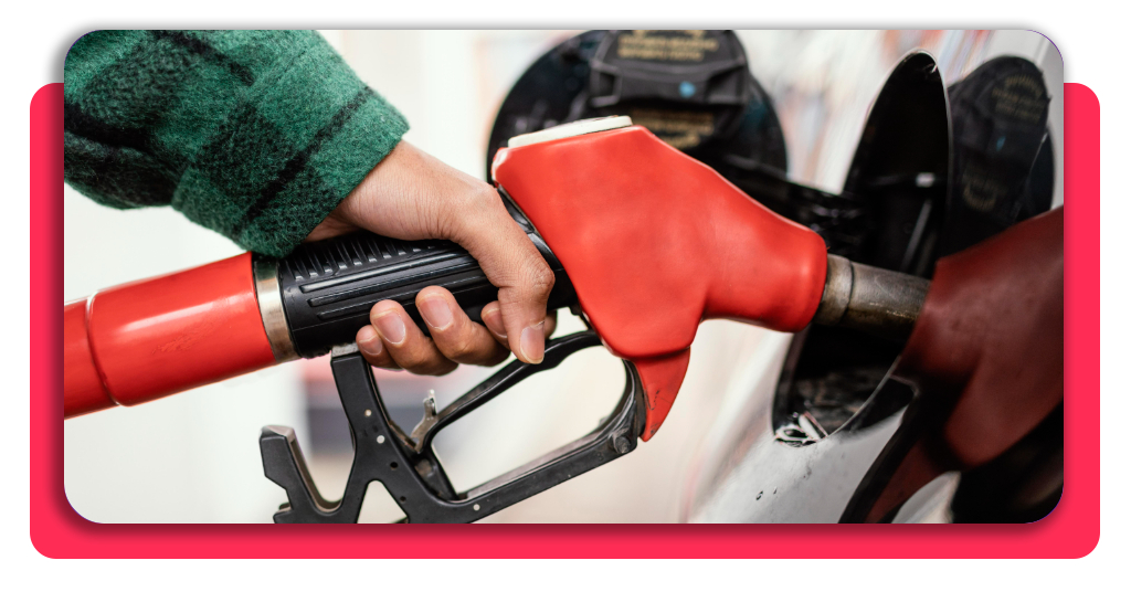 Expendedor de gasolinera atendiendo a un cliente junto a un coche