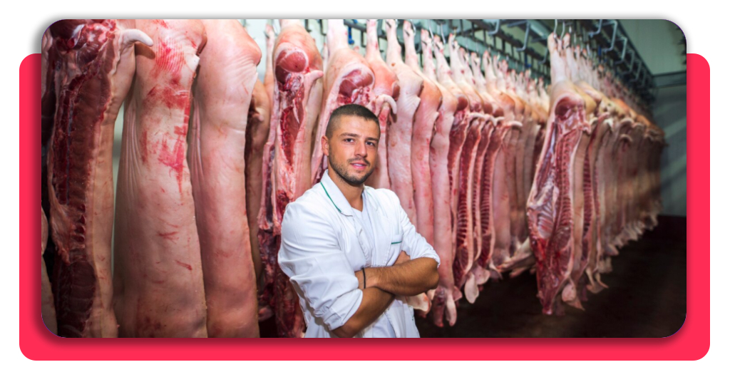 Curso de carnicería gratis: consigue tu certificado y empleo 2 Profesional de la industria alimentaria posando en un almacén de carne, preparado para aplicar las normativas de seguridad e higiene aprendidas.