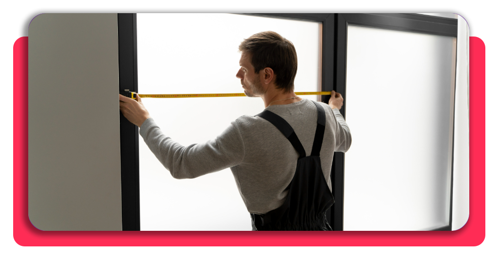 Un carpintero midiendo las dimensiones de una ventana con estructura de metal
